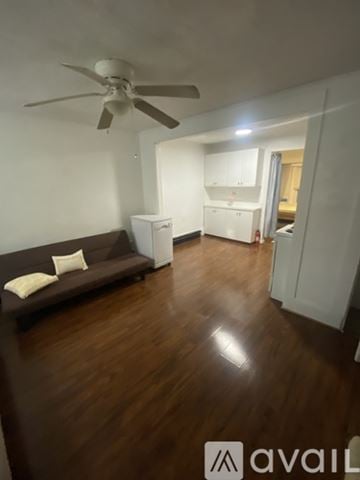 Boston apartment for rent - A living room with a brown couch and a ceiling fan.