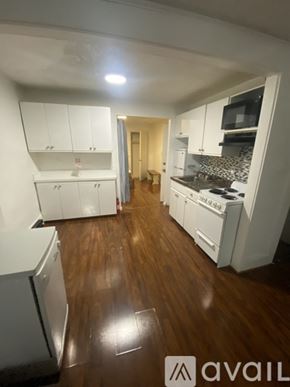 Boston apartment for rent - A kitchen with white cabinets and a wooden floor.