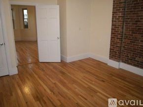 Boston apartment for rent - A room with wooden floors and a white door.