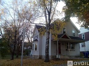 Appleton apartment for rent - A house with a porch and a tree in front of it.