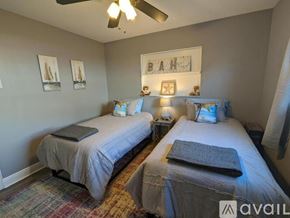 Oakland Park house for rent - A bedroom with two beds and a ceiling fan.