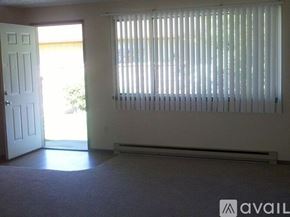 Spokane house for rent - A room with a carpeted floor, a door, and a window with blinds.