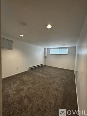 Seattle townhouse for rent - A carpeted room with a window and a wall-mounted heater.