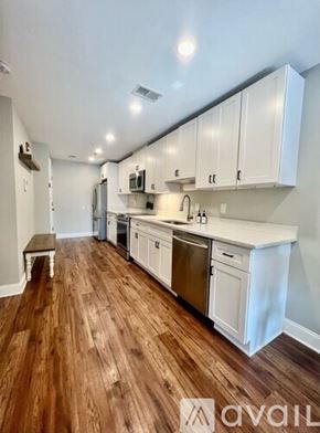 Washington condo for rent - A kitchen with white cabinets and wooden floors.