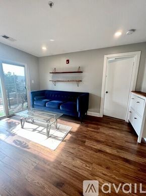 Washington condo for rent - A living room with a blue couch and wooden floors.