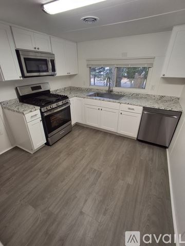 Magalia house for rent - A kitchen with a stove, microwave, and dishwasher.