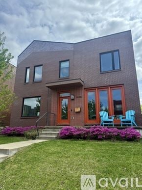 St. Louis house for rent - A house with a red door and windows is surrounded by greenery.