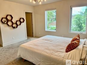 St. Louis house for rent - A bedroom with a bed, a window, and a wall decoration.