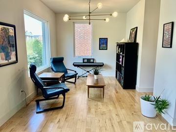 St. Louis house for rent - A living room with a black chair and a wooden coffee table.