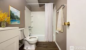Muncie apartment for rent - A white toilet is in a small bathroom with a white bathtub.