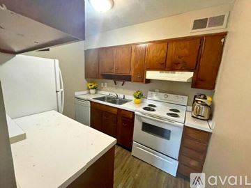 Muncie apartment for rent - A kitchen with white appliances and wooden cabinets.