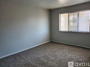 Muncie apartment for rent - A room with a carpeted floor and a window with blinds.