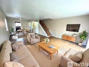 Muncie townhouse for rent - A hallway with a carpeted floor and a wooden staircase.