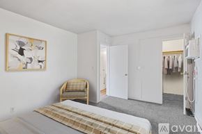 Muncie apartment for rent - A bedroom with a bed, chair, and artwork on the wall.