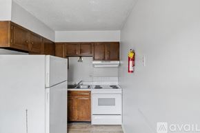 Muncie apartment for rent - A kitchen with white appliances and wooden cabinets.