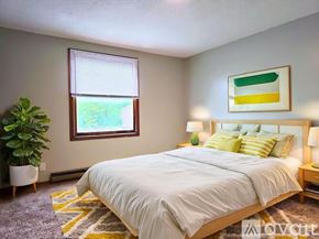Muncie apartment for rent - A bathroom with a toilet, sink, and mirror.