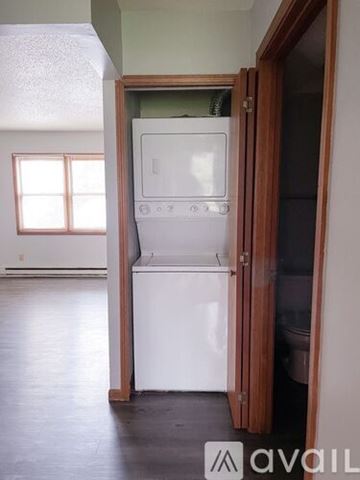 Muncie apartment for rent - A white dishwasher is in a kitchen with a wooden door.