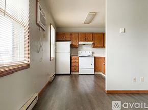 Muncie apartment for rent - A kitchen with white appliances and wooden cabinets.