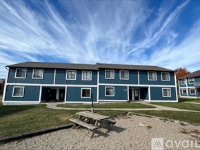 Garrett apartment for rent - A blue building with a picnic table in front of it.
