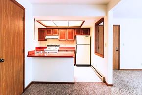 Lagrange apartment for rent - A kitchen with a white refrigerator and wooden cabinets.