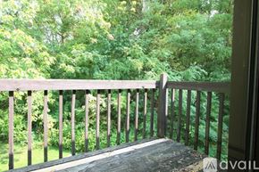 Lagrange apartment for rent - A wooden balcony overlooks a lush green forest.