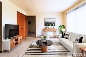 Lagrange apartment for rent - A living room with a white couch, a coffee table, and a television.