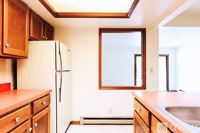 Lagrange apartment for rent - A kitchen with wooden cabinets and a white refrigerator.