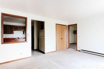 Lagrange apartment for rent - A living room with a kitchen in the background and a carpet on the floor.