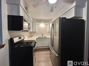 Schiller Park apartment for rent - A kitchen with a refrigerator, sink, and cabinets.