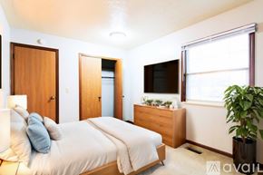 Woodburn apartment for rent - A bedroom with a bed, nightstand, and a window.
