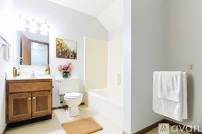 Woodburn apartment for rent - A white toilet sits in a bathroom next to a white bathtub.