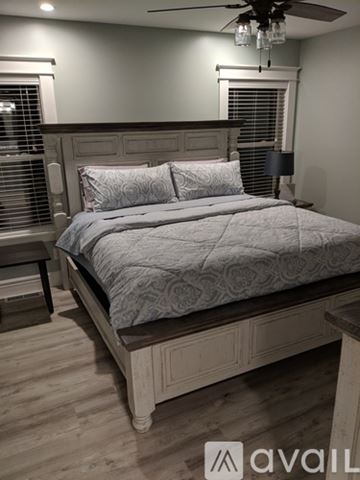 Prescott house for rent - A bedroom with a large bed and a wooden headboard.