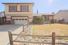 San Jose house for rent - A house with a red garage door and a wooden fence in front.