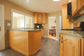 San Jose house for rent - A kitchen with wooden cabinets and a granite countertop.
