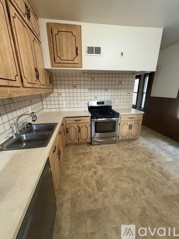 Milwaukee apartment for rent - A kitchen with wooden cabinets and a tiled backsplash.
