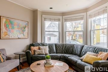 Highland Falls house for rent - A living room with a grey couch and a map of the United States on the wall.