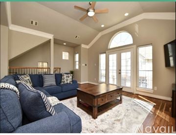 Houston house for rent - A living room with a blue couch and a wooden coffee table.