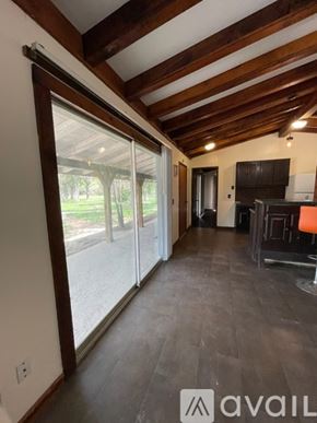 Donna apartment for rent - A living room with a sliding glass door leading to a backyard.