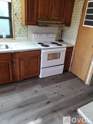 Lago Vista apartment for rent - A kitchen with a white stove and wooden cabinets.