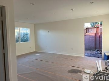 Los Angeles house for rent - A room with a white wall and a window with a view of a fence and trees.