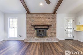 Columbus house for rent - A living room with a brick fireplace and wooden floors.