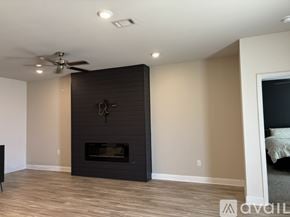 Biloxi house for rent - A modern living room with a fireplace and a ceiling fan.