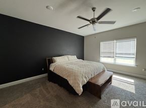Biloxi house for rent - A bedroom with a bed, a ceiling fan, and a window with blinds.