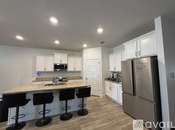 Biloxi house for rent - A kitchen with a granite countertop and bar stools.