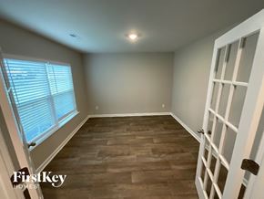 King house for rent - A room with wooden flooring and a white door.