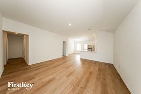 Tuttle house for rent - A spacious room with wooden flooring and white walls.