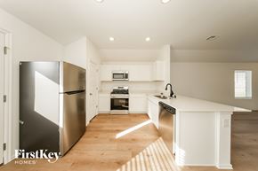 Tuttle house for rent - A kitchen with a refrigerator, microwave, oven, and sink.