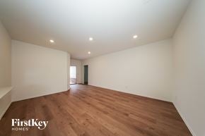 Tuttle house for rent - A spacious room with wooden flooring and white walls.