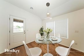 Tuttle house for rent - A dining room with a glass table and white chairs.