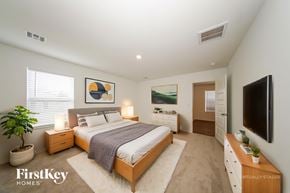 Tuttle house for rent - A bedroom with a bed, nightstands, and a television.